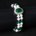 Wholesale Emerald Zircon Bracelet with green oval gem halo centerpiece and double-row pearl strands on platinum plated copper from JuneJewelry.com