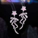 Pink ribbon star CZ drop earrings featuring micro-pave pave bow dangle ribbons, pink crystal star stud top, and 925 sterling silver posts.