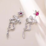 Pink ribbon star CZ drop earrings featuring micro-pave pave bow dangle ribbons, pink crystal star stud top, and 925 sterling silver posts.