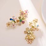 Colorful floral CZ cluster earrings featuring multi-color cubic zirconia flower blossoms set on an 18K gold-plated brass base with 925 sterling silver posts.