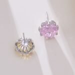 Rose-cut CZ floral stud earrings featuring round rose-faceted center stones framed in micro-pavé CZ scalloped borders, available in soft pink and champagne yellow.