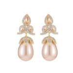 Tear-shaped pearl drop earrings featuring three teardrop crystal clusters top and micro-pavé cap accents, available in gold and palladium plating.