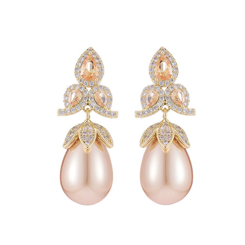 Tear-shaped pearl drop earrings featuring three teardrop crystal clusters top and micro-pavé cap accents, available in gold and palladium plating.