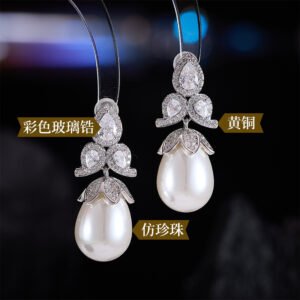 Tear-shaped pearl drop earrings featuring three teardrop crystal clusters top and micro-pavé cap accents, available in gold and palladium plating.
