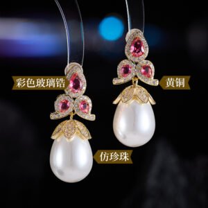 Tear-shaped pearl drop earrings featuring three teardrop crystal clusters top and micro-pavé cap accents, available in gold and palladium plating.