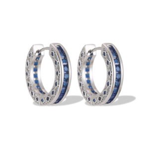 Sapphire blue huggie hoop earrings featuring channel-set princess-cut blue cubic zirconia, side filigree lattice detailing, and platinum plating.