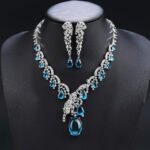 Leopard CZ jewelry set wholesale featuring 3D sculpted panther leopard motifs, tear-drop cubic zirconia stones, statement necklace, and long dangle earrings on 18K gold and palladium plated copper.