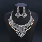 Wholesale Feather Pearl Set featuring a CZ leaf bib necklace with dangling colorful shell pearls on gold plated copper from JuneJewelry.com.