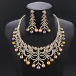 Wholesale Arch Pearl Set featuring a CZ arched leaf bib necklace with dangling colorful shell pearls on gold plated copper from JuneJewelry.com.