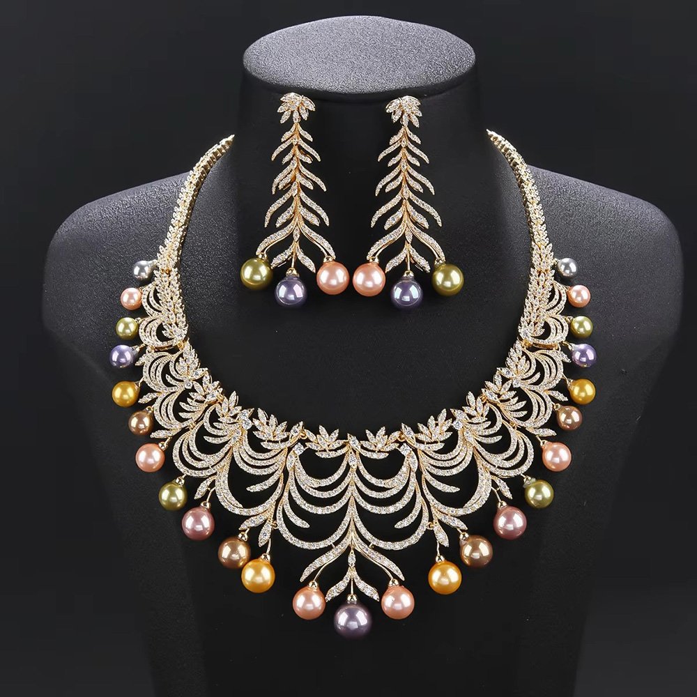 Wholesale Arch Pearl Set featuring a CZ arched leaf bib necklace with dangling colorful shell pearls on gold plated copper from JuneJewelry.com.