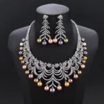 Wholesale Arch Pearl Set featuring a CZ arched leaf bib necklace with dangling colorful shell pearls on gold plated copper from JuneJewelry.com.