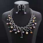 Wholesale Swirl Pearl Set featuring CZ micro paved S-curve links with dangling colorful shell pearls on gold plated copper from JuneJewelry.com.