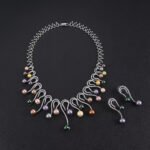 Wholesale Swirl Pearl Set featuring CZ micro paved S-curve links with dangling colorful shell pearls on gold plated copper from JuneJewelry.com.