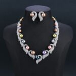 Wholesale Curve Pearl Set featuring CZ paved curl motifs cradling colorful shell pearls on gold plated copper from JuneJewelry.com.