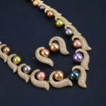 Wholesale Curve Pearl Set featuring CZ paved curl motifs cradling colorful shell pearls on gold plated copper from JuneJewelry.com.