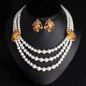 Wholesale Emerald Pearl Set featuring multi strand white shell pearls with green CZ leaf clasps on gold plated copper from JuneJewelry.com.