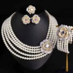 Wholesale Tiered Pearl Set featuring multi strand white shell pearls and CZ orange flower clasps on gold plated copper from JuneJewelry.com.