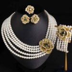 Wholesale Tiered Pearl Set featuring multi strand white shell pearls and CZ orange flower clasps on gold plated copper from JuneJewelry.com.