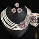 Wholesale Tiered Pearl Set featuring multi strand white shell pearls and CZ orange flower clasps on gold plated copper from JuneJewelry.com.