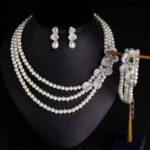 Wholesale Wave Pearl Set featuring multi strand white shell pearls with CZ paved wave flower clasps on gold plated copper from JuneJewelry.com.