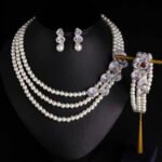 Wholesale Wave Pearl Set featuring multi strand white shell pearls with CZ paved wave flower clasps on gold plated copper from JuneJewelry.com.