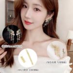 Multicolor rainbow CZ angel wing drop earrings featuring curved wing tops, dangling colorful cz stone strands, star accents, and 16K gold plating.