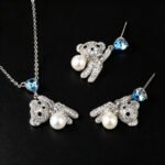 Wholesale pearl bear jewelry set featuring platinum plated copper with blue heart Swarovski element crystals and white pearls from JuneJewelry.com.