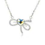 Swarovski crystal heart bow necklace wholesale made with palladium plated brass chain, pave cz bowknot, dainty pearl accents, and heart crystal, SKU G101034E.
