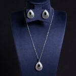 Niche layered teardrop jewelry set wholesale featuring a multi-layer hollow pave cubic zirconia teardrop pendant necklace with matching stud earrings from junejewelry.com