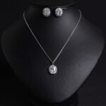 Niche emerald cut halo zircon jewelry set wholesale featuring an octagon emerald-cut gemstone surrounded by a baguette cubic zirconia halo with matching stud earrings from junejewelry.com