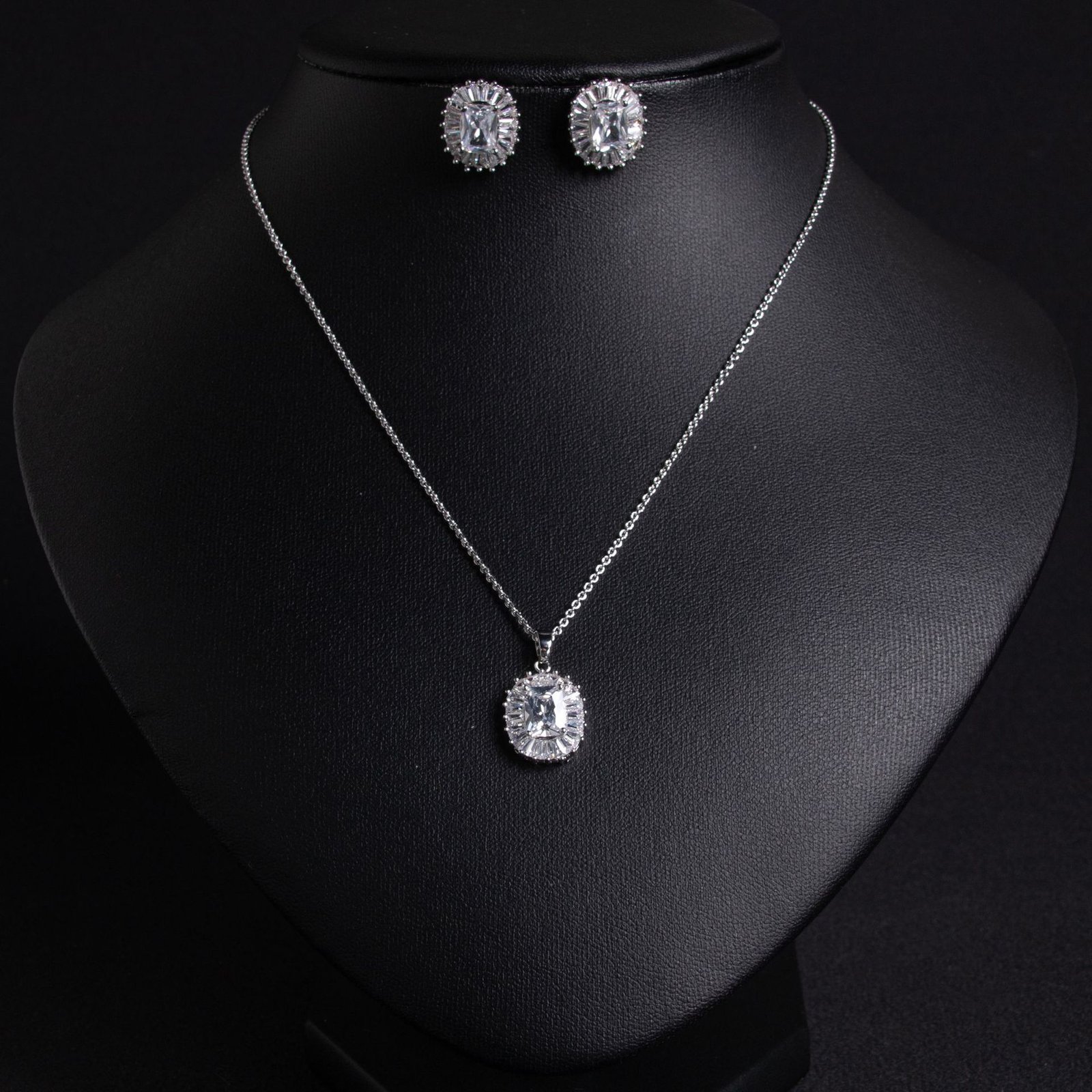 LJT4292 (8) Niche emerald cut halo zircon jewelry set wholesale featuring an octagon emerald-cut gemstone surrounded by a baguette cubic zirconia halo with matching stud earrings from junejewelry.com