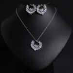 Niche hollow heart crystal jewelry set wholesale featuring an openwork marquise cubic zirconia heart wreath pendant necklace and matching heart earrings from junejewelry.com