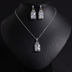 Niche emerald cut zircon halo jewelry set wholesale featuring a rectangular emerald-cut main gem inside an intricate pave cubic zirconia filigree frame with matching drop earrings from junejewelry.com