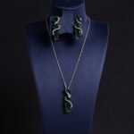 Niche cascading teardrop zircon jewelry set wholesale featuring a vertical geometric arrangement of gradient teardrop stones wrapped in a micro-pave wave with matching drop earrings from junejewelry.com