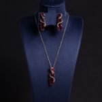 Niche cascading teardrop zircon jewelry set wholesale featuring a vertical geometric arrangement of gradient teardrop stones wrapped in a micro-pave wave with matching drop earrings from junejewelry.com