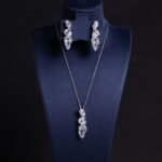 Niche cascading teardrop zircon jewelry set wholesale featuring a vertical geometric arrangement of gradient teardrop stones wrapped in a micro-pave wave with matching drop earrings from junejewelry.com