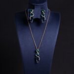 Niche cascading teardrop zircon jewelry set wholesale featuring a vertical geometric arrangement of gradient teardrop stones wrapped in a micro-pave wave with matching drop earrings from junejewelry.com