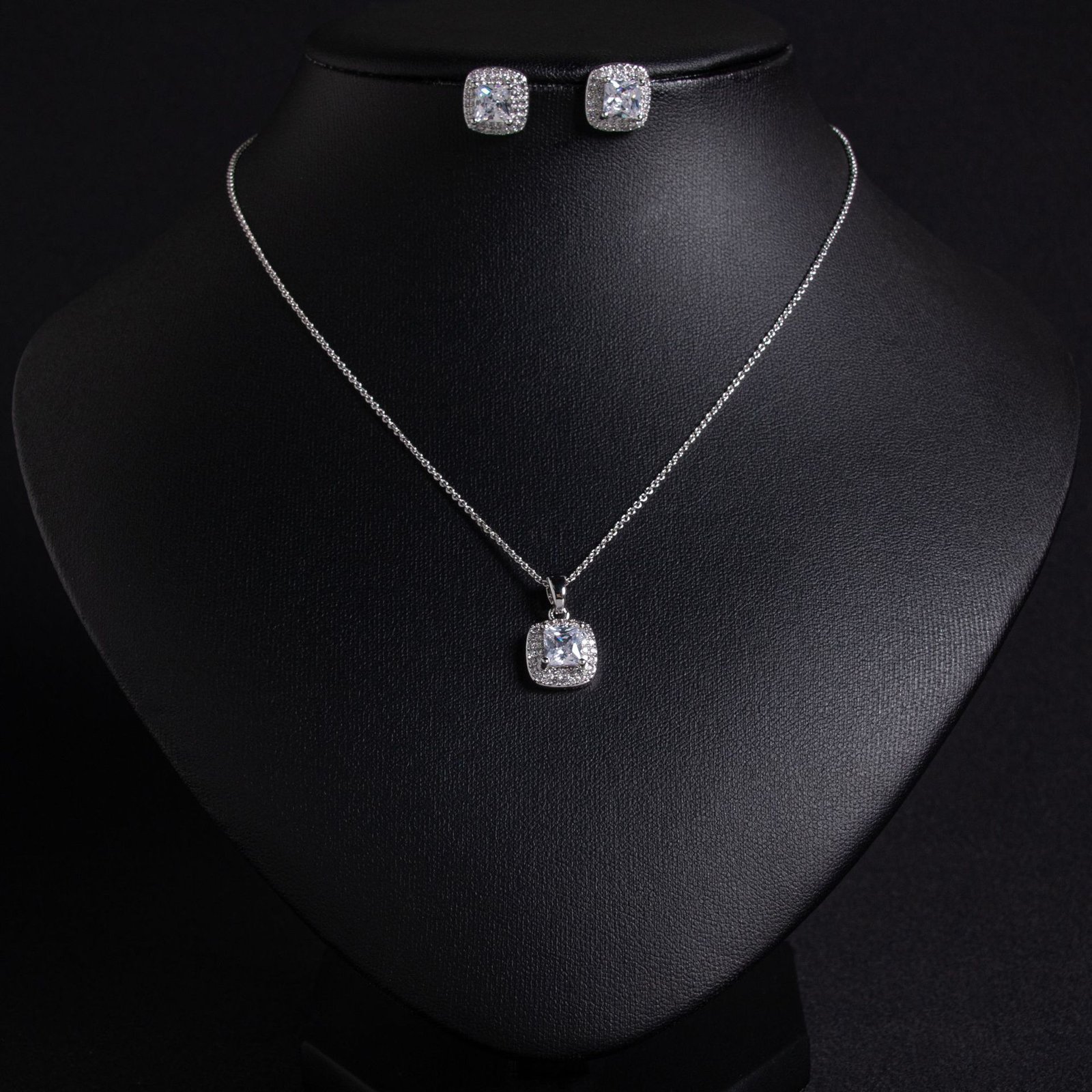 LJT6215 (4) Niche square halo zircon jewelry set wholesale featuring a cushion-cut center gem enclosed by a pave cubic zirconia halo with matching stud earrings from junejewelry.com