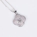 Niche four-leaf clover zircon jewelry set wholesale featuring a micro-pave cubic zirconia clover motif with a central pinwheel star icon and matching stud earrings from junejewelry.com