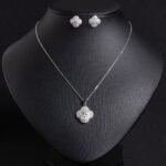 Niche four-leaf clover zircon jewelry set wholesale featuring a micro-pave cubic zirconia clover motif with a central pinwheel star icon and matching stud earrings from junejewelry.com