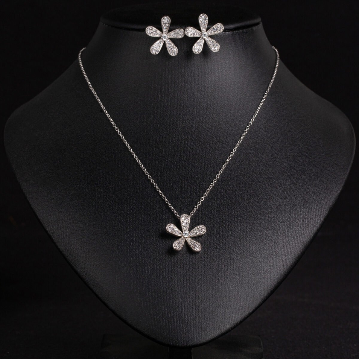 Niche five petal flower jewelry set wholesale featuring a delicate micro-pave CZ five petal blossom pendant necklace and matching flower stud earrings from junejewelry.com