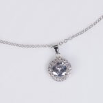 Niche round halo zircon jewelry set wholesale featuring a brilliant round-cut central crystal surrounded by a pave cubic zirconia halo with matching stud earrings from junejewelry.com