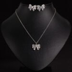 Niche bowknot crystal jewelry set wholesale featuring a sparkly baguette cubic zirconia ribbon bow pendant chain necklace and matching stud earrings from junejewelry.com