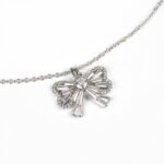 Niche bowknot crystal jewelry set wholesale featuring a sparkly baguette cubic zirconia ribbon bow pendant chain necklace and matching stud earrings from junejewelry.com