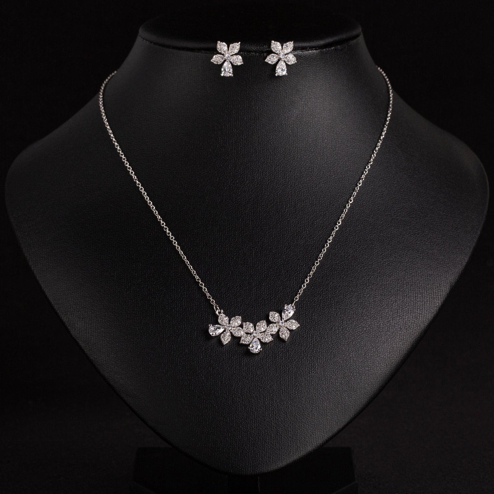 LJT89552 (2) Niche triple flower crystal jewelry set wholesale featuring a curved garland of pave CZ flowers with teardrop crystal accents and matching floral stud earrings from junejewelry.com