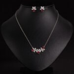 Niche triple flower crystal jewelry set wholesale featuring a curved garland of pave CZ flowers with teardrop crystal accents and matching floral stud earrings from junejewelry.com