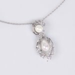 Niche pearl floral zircon jewelry set wholesale featuring a double-tiered synthetic pearl design framed with pave-set cubic zirconia leaf motifs and matching drop earrings from junejewelry.com