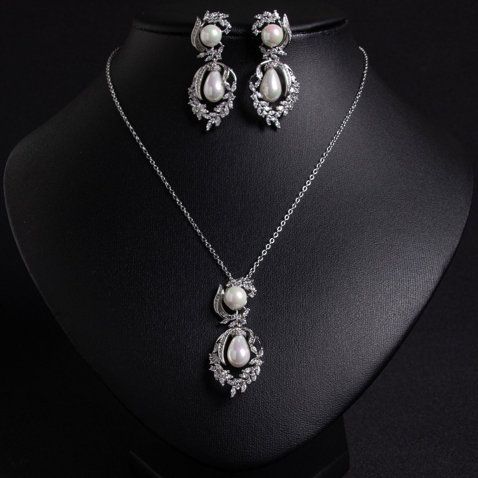 LJT89651 (6) Niche pearl floral zircon jewelry set wholesale featuring a double-tiered synthetic pearl design framed with pave-set cubic zirconia leaf motifs and matching drop earrings from junejewelry.com