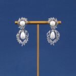 Niche pearl floral zircon jewelry set wholesale featuring a double-tiered synthetic pearl design framed with pave-set cubic zirconia leaf motifs and matching drop earrings from junejewelry.com