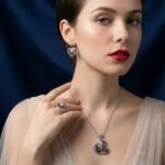 Niche swirl heart crystal jewelry set wholesale featuring an openwork filigree swirl heart pendant necklace, statement ring, and matching drop earrings studded with cubic zirconia from junejewelry.com